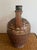 An earthenware ewer with an animal head spout with an open mouth and tooled fur texture. Consistent with rural pottery...