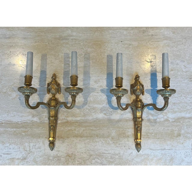 This beautiful set of four wall sconces is made of chiseled bronze. It is a French work in the Louis XVI style. Circa 1940