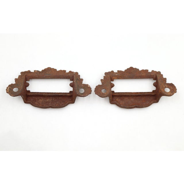 Victorian cast iron apothecary bin pulls with a label slot. The original mounting screws are not available. Good condition...