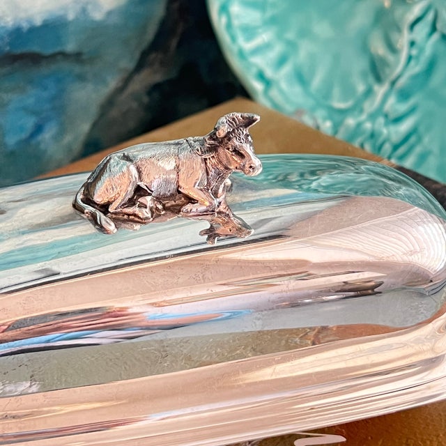 Elevate your dining experience with the Antique Reed & Barton Silverplate Butter Dish. Featuring a delightful cow finial,...