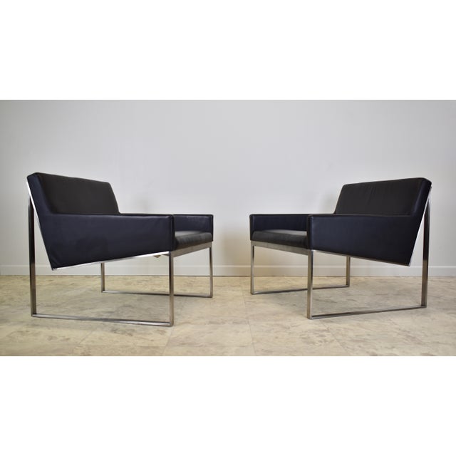 A pair of high quality black leather upholstered and brushed nickel frame lounge chairs designed by Fabien Baron for...