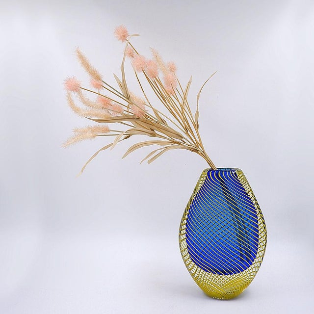 Optic Twist Vase - Art Glass Vase Masures : 18x7cm H:27,5cm This hand-blown glass vase features a shimmering blue...