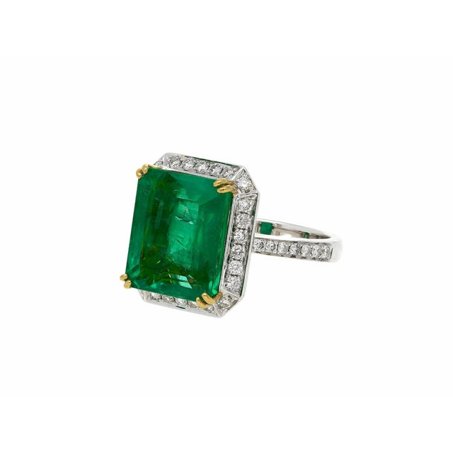 8 carat natural Colombian Emerald mounted in an 18k white gold setting featuring a round diamond halo. A classic and...