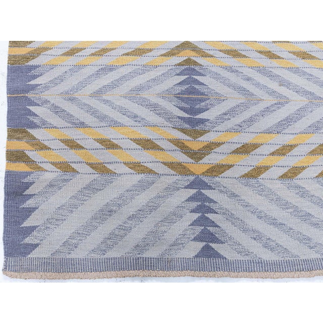 This modern Swedish flat weave rug presents a refined geometric composition distinguished by crisp chevron and diamond...