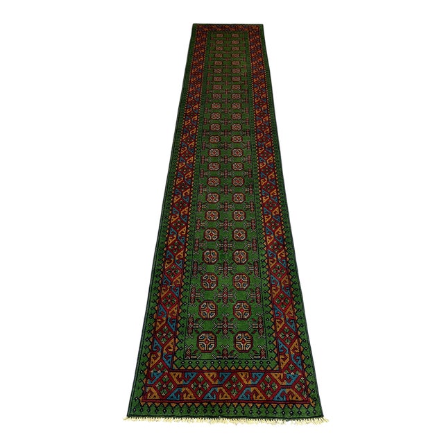 This green tribal runner features a repeating Mori Gul geometric design that draws the eye along its length. Its narrow...