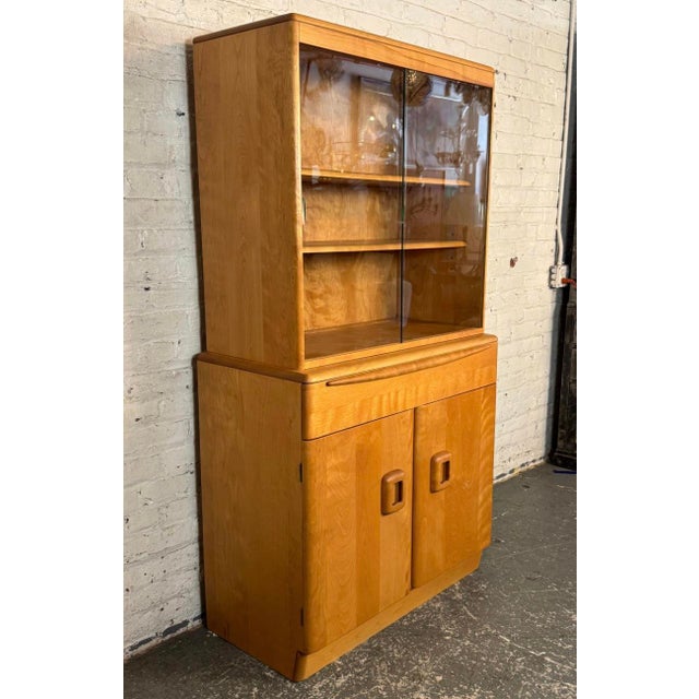 Mid-Century Modern china cabinet by Heywood-Wakefield, circa 1960s. Featuring a distinctive "Champagne" finish, the...