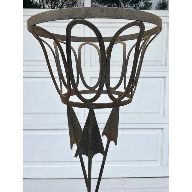 Here is a statement jardiniere in the style of Jansen, made of black iron and featuring 3 tall figurative arrows as the...