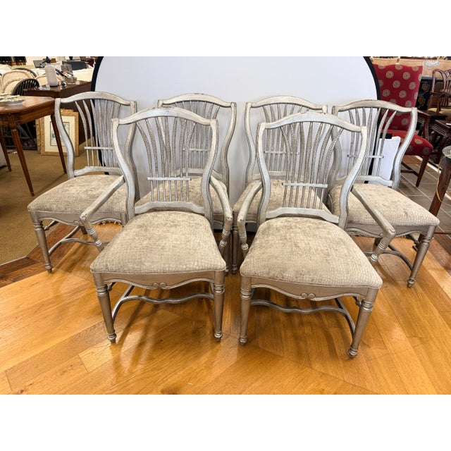 A beautiful and cohesive set of six dining chairs in a distressed silver-grey painted finish. The carved wheat-sheaf splat...