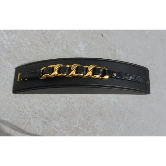 Vintage 90s Chanel black leather and Gilt link buckle bracelet. Woven leather through each link with Chanel marks on the...