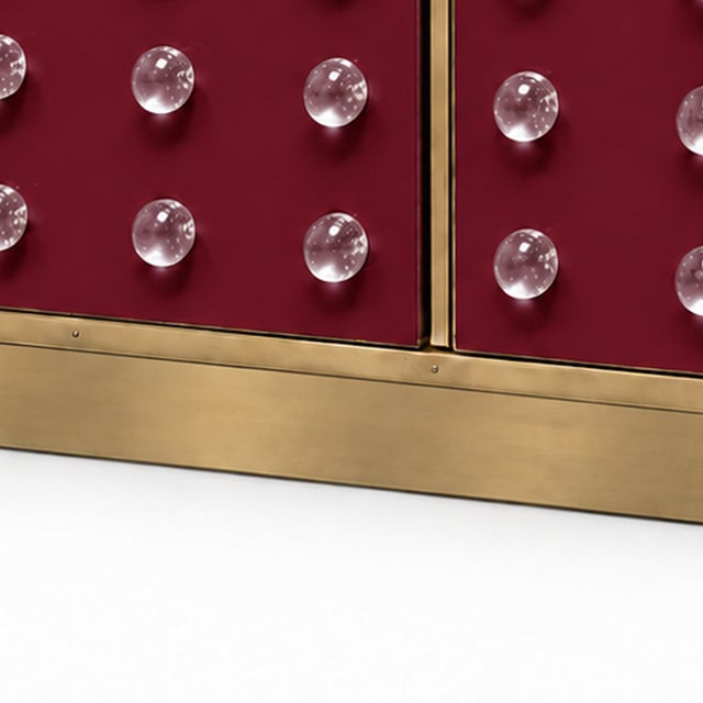 A sculptural italian dry bar in a saturated burgundy murano glass finish, with 40 clear glass spheres arranged across the...
