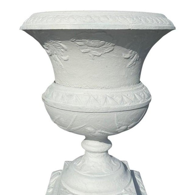 An antique classical garden urn, crafted from cast iron and dating to approximately 1920. This substantial outdoor...
