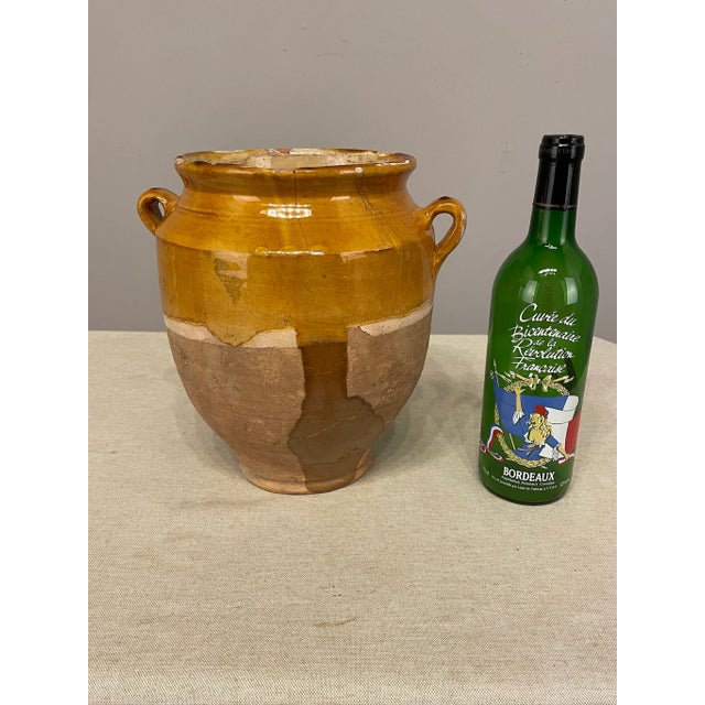 An earthenware confit pot from the Southwest of France with traditional yellow, ochre glaze. Minor chips and losses to...