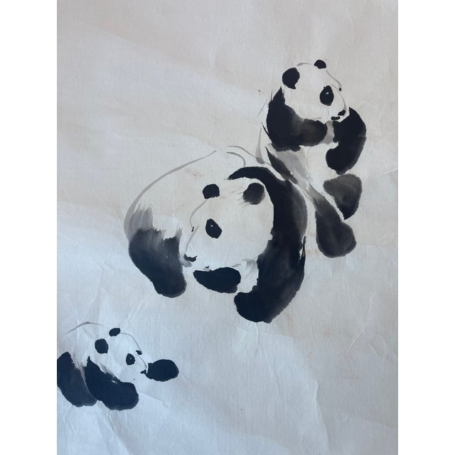 This vintage ink painting by J.P.Gaston captures a tender moment among a family of three pandas, depicted in a traditional...