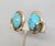1950s oval goldtone cabochon faux-turquoise with loop decoration clip earrings. Marked "NAPIER PAT. PEND." on the clips....