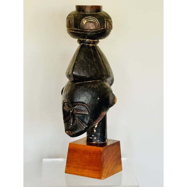 A carved wooden head with vessel. Attributed to the Guro people of Ivory Coast. Mounted on a later Walnut display plinth.