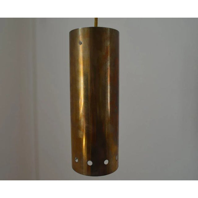 This pendant light from the 1960s features a tubular shade in golden brass. European Plug (up to 250V).The wiring of this...