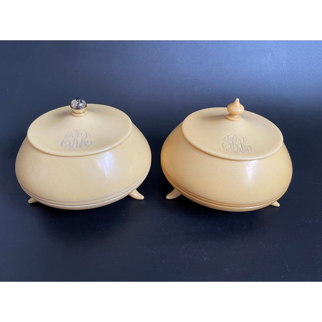 A pair of antique French Ivory (celluloid) vanity jars by Titterton, England. The set features a two tone design, with...
