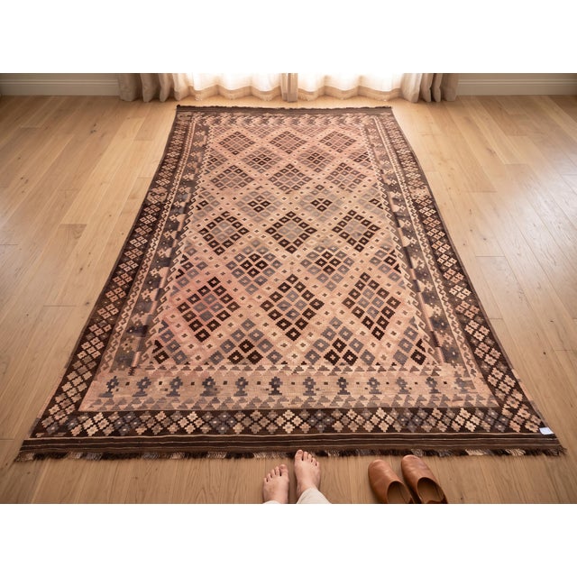 This oversized vintage kilim, believed to date from the 1990s, is handwoven in a traditional flatweave construction. An...