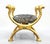 Striking Italian Egyptian Revival curule chair dating to the 1970s–1980s, distinguished by an expressive sculptural frame...