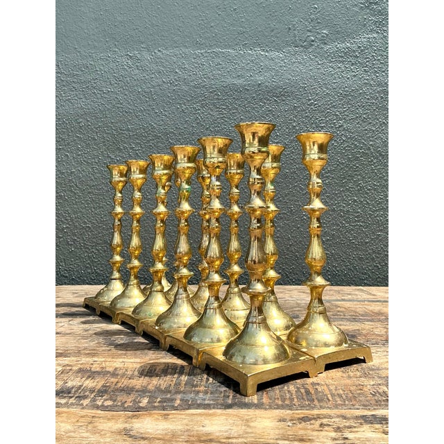 Elevate your tablescape with this striking collection of twelve vintage brass candlesticks. Characterized by their elegant...