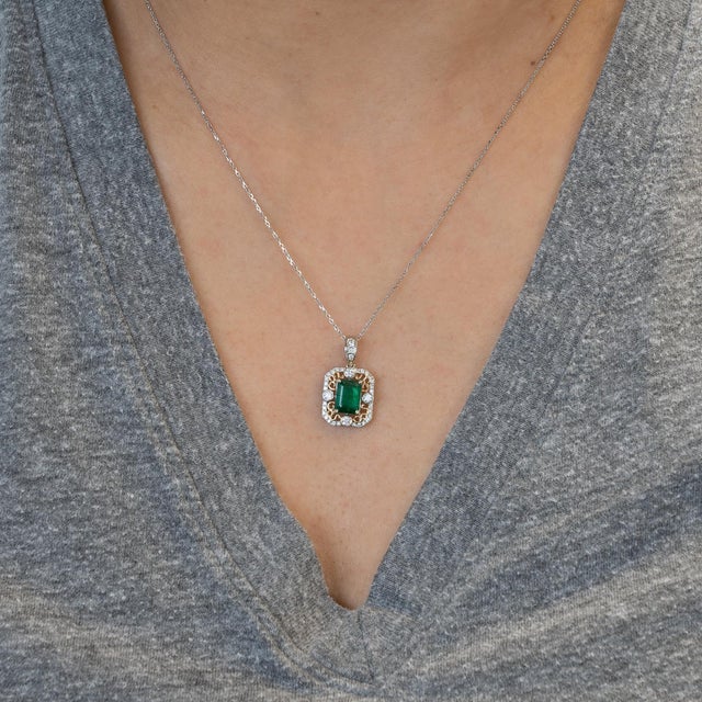 Elegant 1.4ct natural emerald (7x5mm) pendant accented with sparkling natural diamonds, set in solid 14K gold for timeless...
