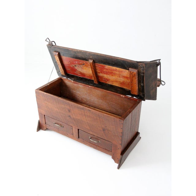 Antique buggy seat set over a fitted case base, retaining its original curved wood back and iron supports. The form...