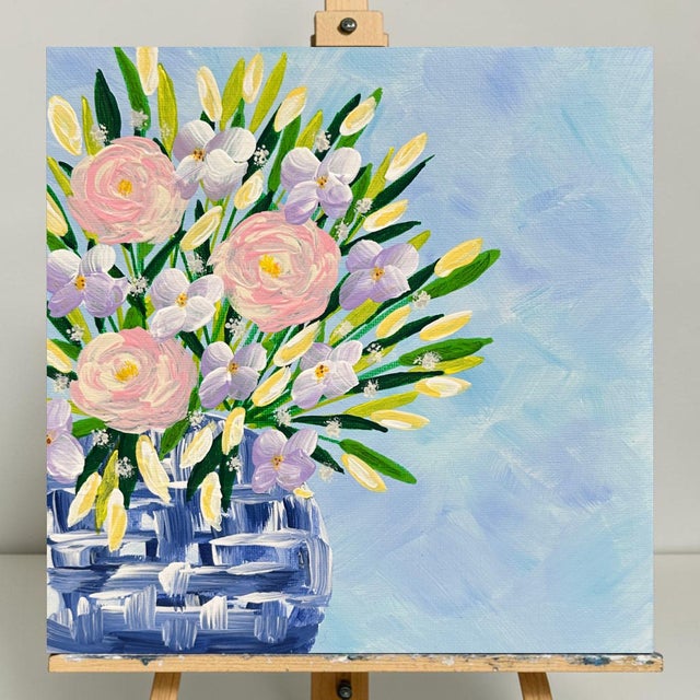 This acrylic painting of a delicate floral bouquet in a blue and white chinoiserie vase filled with beautiful spring...