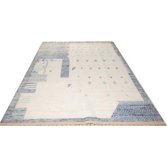 This hand knotted pile rug features a primary gray color palette and is crafted from 100% natural wool. Representing the...