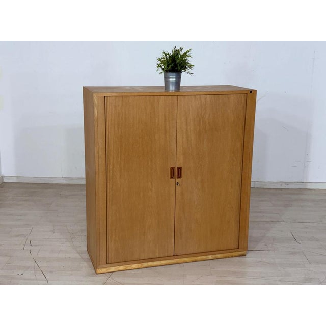 For sale is an elegant vintage wardrobe from the Danish manufacturer Nipu. This piece of furniture features two smooth-...