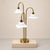 Vintage 1960s Hollywood Regency brass table lamp. This piece has 3 bulbs, all which are on bent brass, cascading waterfall...