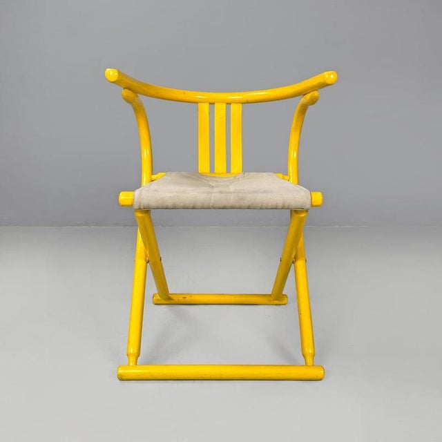 Italian post-modern folding tub chair in yellow wood and beige fabric, 1980s Folding cockpit chair with yellow painted...