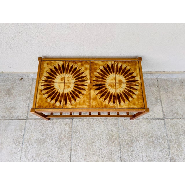 Stunning vintage coffee table with a design typical of the 1960s. it features a solid wood frame and a top adorned with...