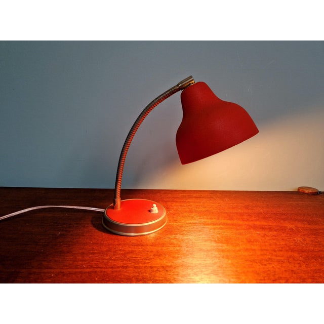 Articulated desk lamp in brass and red lacquered metal, 1950s. It has been re-electrified and is compatible with a B22 LED...