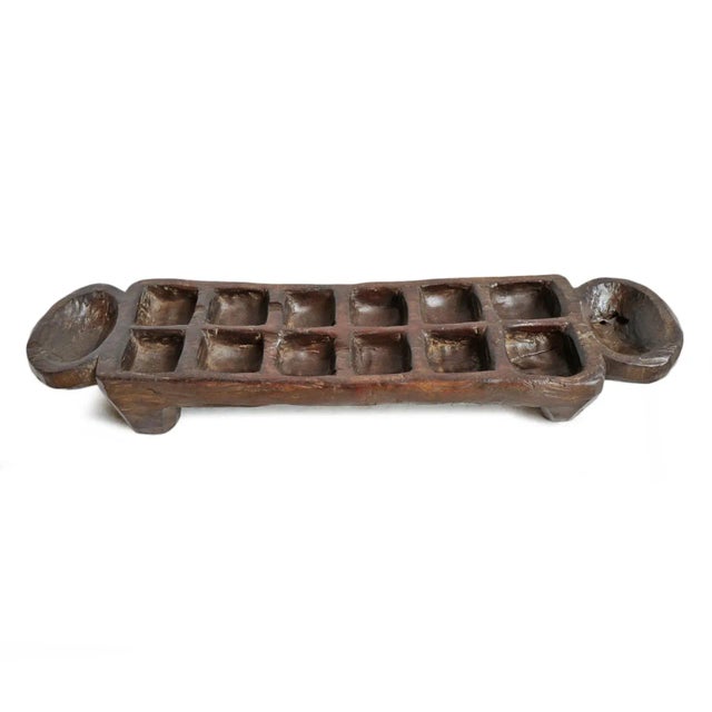 Old carved wood mancala game board. Dark espresso stain and original signs of age and use. Game board only - no playing...