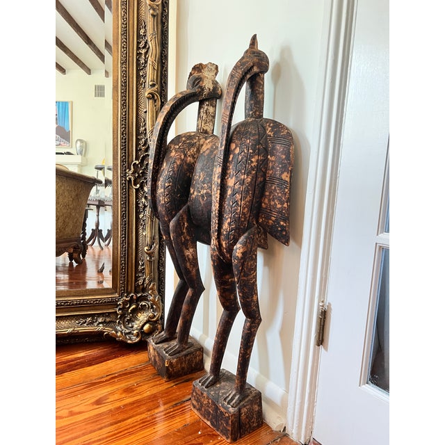 Monumental pair of hand-carved West African bird sculptures in the Senufo sejen hornbill tradition, each individually...