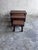 A sculptural set of three nesting tables dating from the 1970s. The tables feature warm, dark-stained wooden tops, softly...