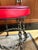 A sculptural accent stool containing heavy welded iron chain links. The base has a beautiful aged patina consistent with...