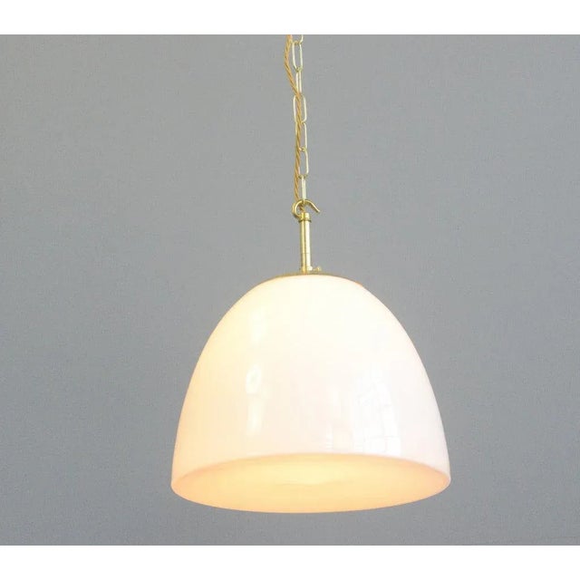 - Opaline glass with a slight concave and point on the underneath - Brass monks cap top - Takes E27 fitting bulbs - Comes...