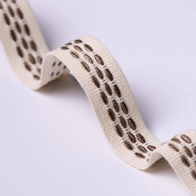 Stitches in variegated tones form a dappled stripe pattern on an understated high-performance tape with loads of tactile...