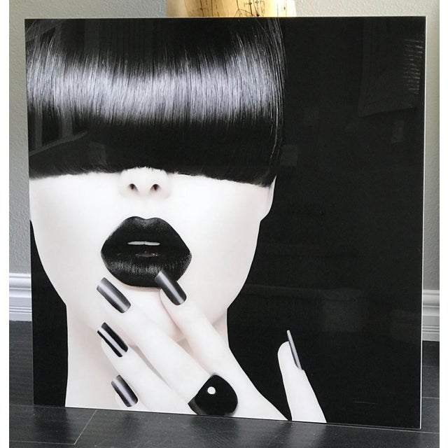A stunning large format photography mounted on acrylic featuring a woman with jet back hair and porcelain skin-- very...