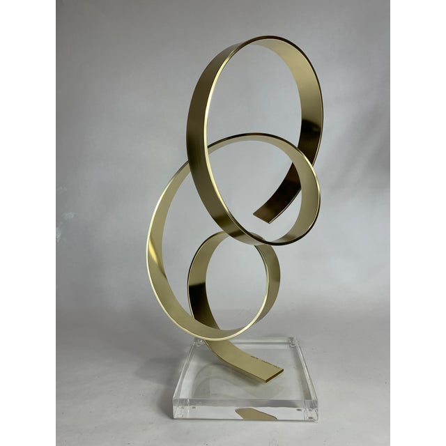 A modern sculpture by Dan Murphy. Of gold aluminum, the element reaches to the sky