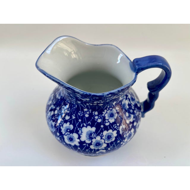 A Vintage English Victoria Ware Ironstone pitcher, Circa, 1940s. Decorated with a blue and white floral pattern, commonly...