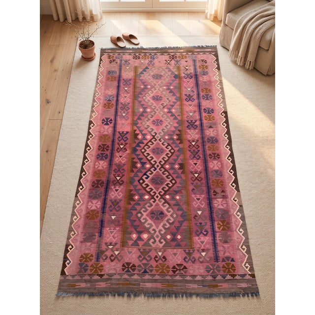 A handwoven Maimana kilim from northern Afghanistan in a saturated rose pink, worked with navy, mustard, chocolate and...