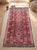 A handwoven Maimana kilim from northern Afghanistan in a saturated rose pink, worked with navy, mustard, chocolate and...