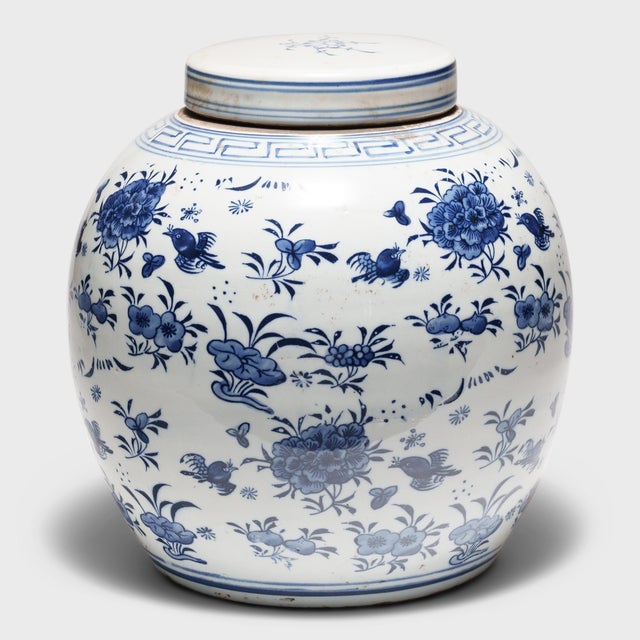 This round, porcelain storage jar is brightly glazed in the classic blue-and-white manner with allover pattern of birds...
