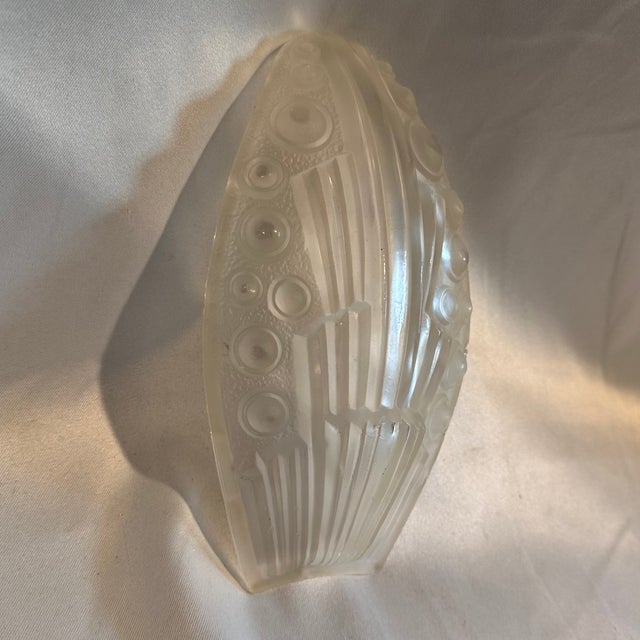 A 1930's era Art Deco clear and textured slip shade measuring 9.5" H x 5.25"W x 3"W at bottom. Fixture not included. No...