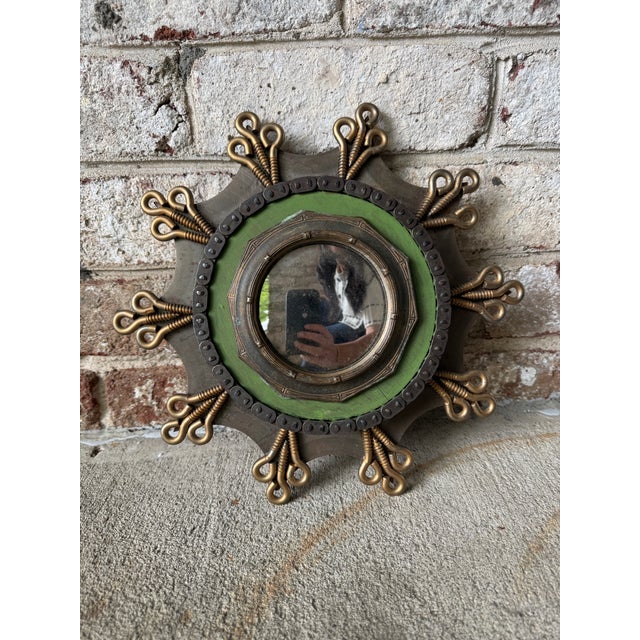 Quirky and unique green and metal industrial wall mirror. This small round mirror is filled with character, featuring...