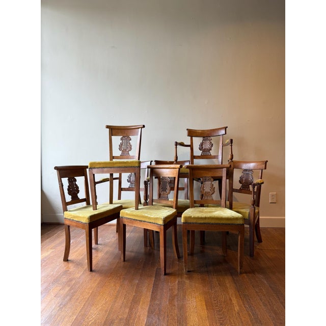 This set of eight 19th Century Neoclassical dining chairs features an upholstered seat cushion with a distinctive...