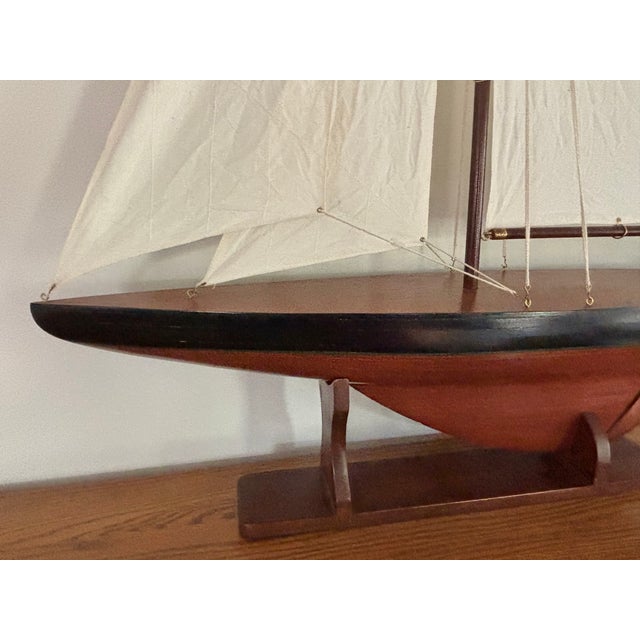 Vintage coastal scale model sailboat, a classic in nautical design. This beautifully rendered model features a dark wood...