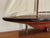 Vintage coastal scale model sailboat, a classic in nautical design. This beautifully rendered model features a dark wood...